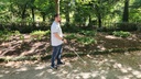 Utilisateur se déplaçant avec une canne blanche équipée de l'ICane, sur un chemin dans un parc